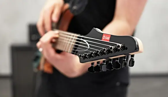 Close up of the head of a G4M guitar being played